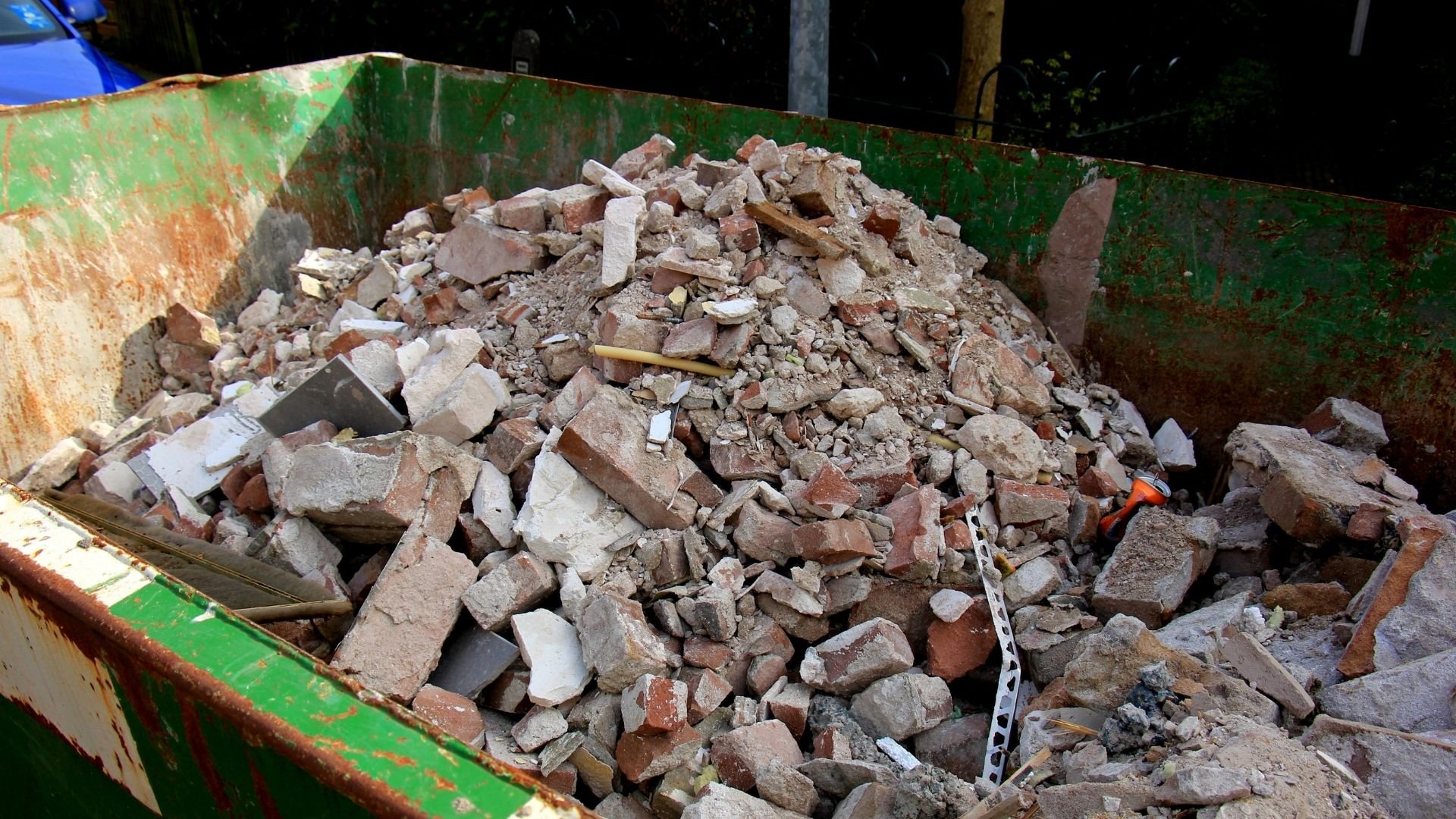 Dumpster filled with broken bricks and construction debris waste